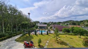 a red motorcycle parked in front of a house at Samati Hill - Sunset Pool Villa 7 - Klong Ning Beach in Ko Lanta Yai