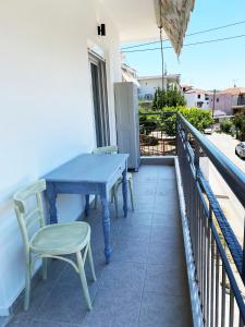 a blue table and chairs on a balcony at Sadin apartment in Neos Marmaras