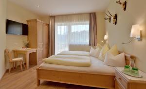 Postel nebo postele na pokoji v ubytování Das Sonnleiten Ski- und Motorradhotel Bruck im Zillertal