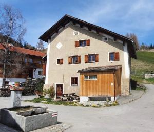 a large house with a wooden door and a courtyard at Arvenstube - Wergenstein in Wergenstein