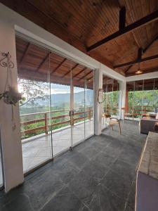 a living room with large windows and a view of a mountain at Refúgio da Zena in Mairiporã