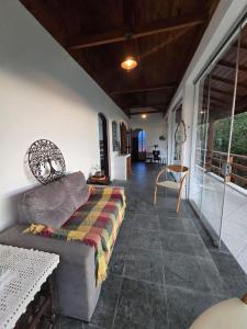 a living room with a couch and a balcony at Refúgio da Zena in Mairiporã