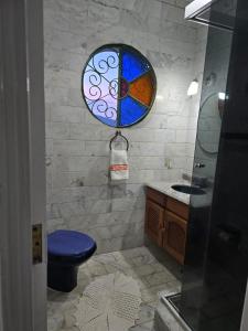 a bathroom with a blue toilet and a stained glass window at Refúgio da Zena in Mairiporã +30 photos