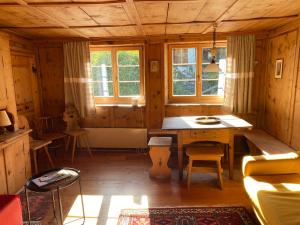 a wooden room with a table and a window at Arvenstube - Wergenstein in Wergenstein