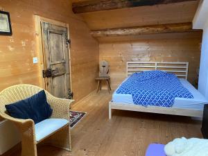 a bedroom with a bed and a chair in a cabin at Arvenstube - Wergenstein in Wergenstein