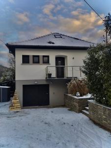 een wit huis met een garage in de sneeuw bij Le Ptit Lou in Kaysersberg