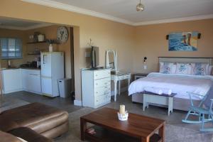 a bedroom with a bed and a desk and a kitchen at Seas the Breeze in Boknes