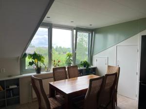 una sala da pranzo con tavolo, sedie e finestre di Boerderij Hazenveld a Kockengen