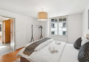 a white bedroom with a large bed and a window at The R Apartment Hemmental in Schaffhausen