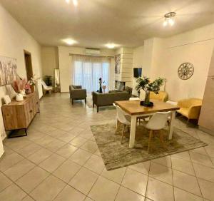 un ampio soggiorno con tavolo e divano di Zephyrus Cityscape Condo,By IdealStay Experience a Heraklion