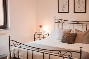 a bedroom with a bed with white sheets and pillows at Villa bif. nel verde tra Bobbio/Grazzano/1h Milano in Viserano