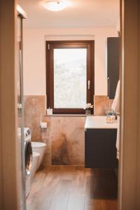 un bagno con lavandino, WC e finestra di Villa bif nel verde tra BobbioGrazzano1h Milano a Viserano Altre 30 foto