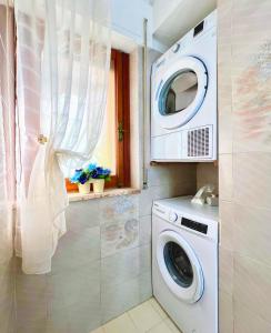 una lavatrice e asciugatrice in un bagno con finestra di Gente di Mare Apartment Tropea Center a Tropea