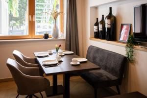 a dining room table with chairs and wine bottles at Strommer wine das Gästehaus in Purbach am Neusiedlersee