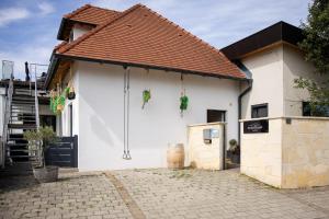 a white building with a brown roof at Strommer wine das Gästehaus in Purbach am Neusiedlersee