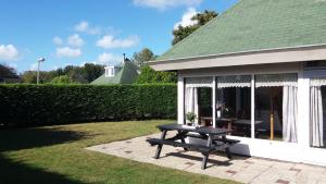 a picnic table sitting outside of a house at Bungalowpark De Toekomst in Ouddorp