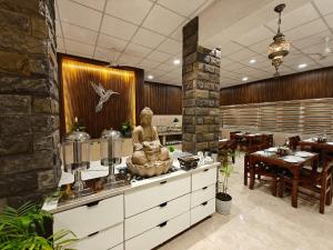 a restaurant with a statue of a woman on a counter at Nyotel-MP Nagar Bhopal in Bhopal