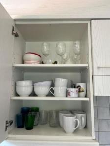 un mobile pieno di piatti, tazze e ciotole di WEF Davos - Private Room in Shared Apartment a Davos