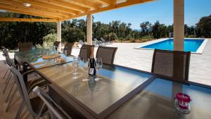 a dining table with wine glasses and a swimming pool at Villa Cyprian by Villas Guide in Kampor