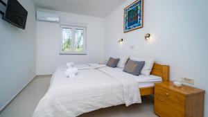 a bedroom with a bed with a teddy bear on it at Villa Cyprian by Villas Guide in Kampor +32 photos