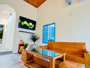 a living room with a glass table and a bench at MIA Villa in Tiến Thành