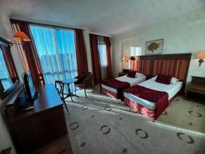 een hotelkamer met twee bedden en een televisie bij Efir in Stara Zagora +16 foto's