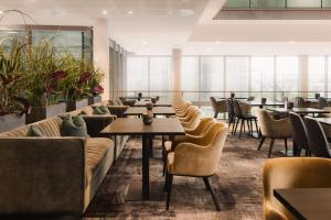 un ristorante con divani, tavoli e sedie di Scandic Stavanger Airport a Sola