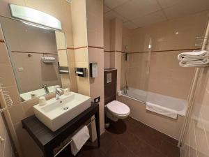 een badkamer met een wastafel, een toilet en een douche bij Kyriad Hotel Dijon Gare in Dijon +56 foto's