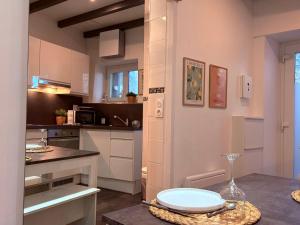 a kitchen with white cabinets and a counter top at Studio, terrasse & cathédrale in Valence