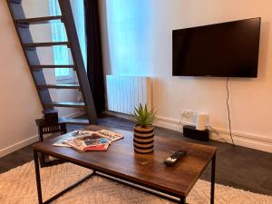 a living room with a coffee table and a flat screen tv at Studio, terrasse & cathédrale in Valence