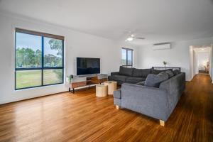 a living room with a couch and a tv at Long Island Retreat - Rosella in Murray Bridge