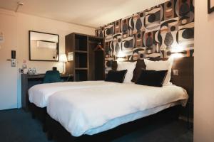 een hotelkamer met een groot bed en een bureau bij Brit Hotel Confort Orly Morangis in Morangis