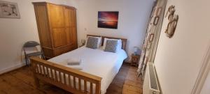 a small bedroom with a bed and a ladder at Sage Cottage Ventnor in Ventnor