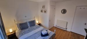 a bedroom with a bed with a blue comforter at Sage Cottage Ventnor in Ventnor +1 photo