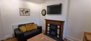a living room with a couch and a fireplace at Sage Cottage Ventnor in Ventnor