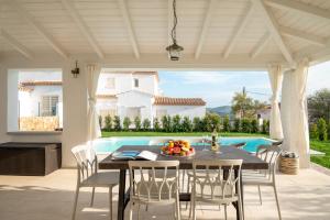 a patio with a table and chairs and a pool at Villa Ca' La Luna by Klodge in Budoni