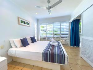 a bedroom with a large bed and a window at Coastal at Mango House in Airlie Beach