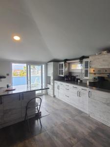 a kitchen with white cabinets and a table and a chair at Golden Moon Hotel in Fethiye
