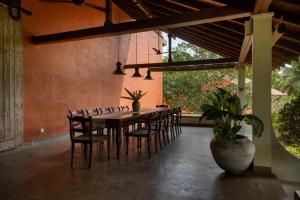 a dining room with a long table and chairs at Mimosa Hill in Hiriketiya