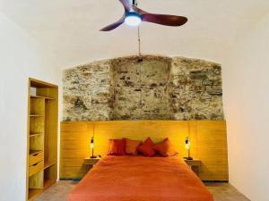 a bedroom with a large bed with a ceiling fan at Montera appartement centre ville avec piscine chauffée et jardin in Bastia