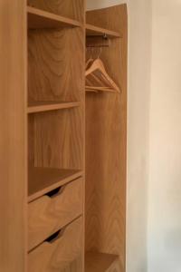 a walk in closet with wooden shelves at Montera appartement centre ville avec piscine chauffée et jardin in Bastia