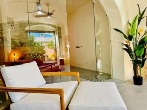 a living room with two white chairs and a window at Montera appartement centre ville avec piscine chauffée et jardin in Bastia +25 photos