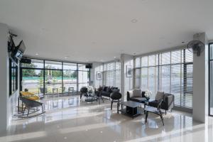 a living room with chairs and tables and windows at ซีทูยู อุทัยธานี in Ban Wang Yang