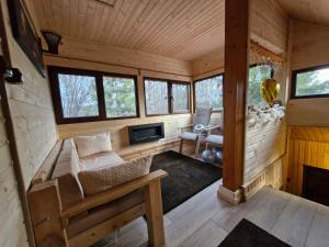 een woonkamer van een blokhut met een bank en een open haard bij Cabana din Padurea Valeni in Vălenii de Munte