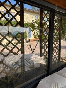 a window with a view of a courtyard at Le clos des Oiseaux in Itzac