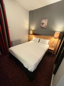 een slaapkamer met een groot wit bed met twee lampen bij Kyriad Hotel Dijon Gare in Dijon