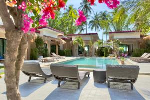 a resort swimming pool with chairs and pink flowers at Pinky Bungalows Resort & Villa in Ko Lanta