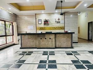 a lobby with a counter and a tile floor at Hotel Surya in Mangalore