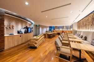 a restaurant with wooden tables and chairs and a bar at Hotel Gracery Sapporo in Sapporo
