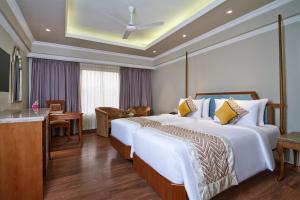 a hotel room with two beds and a desk at Hotel Swosti Premium Bhubaneswar in Bhubaneshwar +31 photos